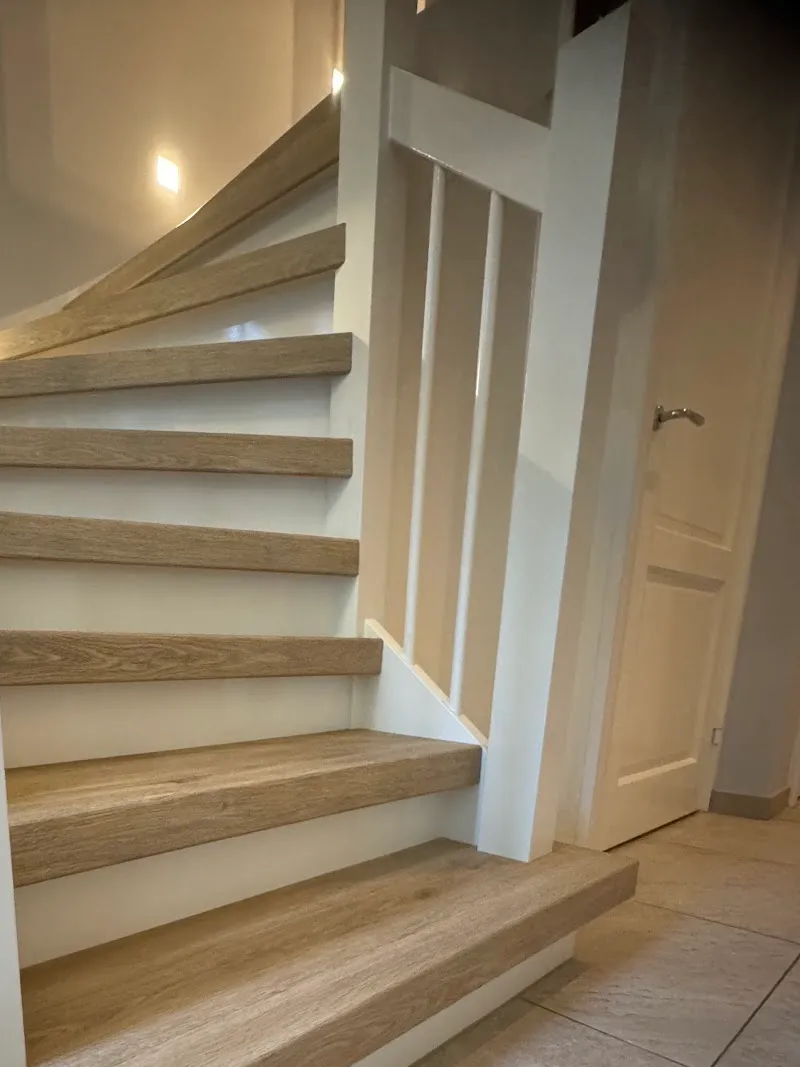 Trap met eiken treden en witte spijlenbalustrade